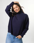 Woman wearing mixed wool navy jumper with turtleneck by brand Stella & Gemma posed front view