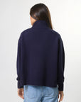 Woman wearing mixed wool navy jumper with turtleneck by brand Stella & Gemma back view