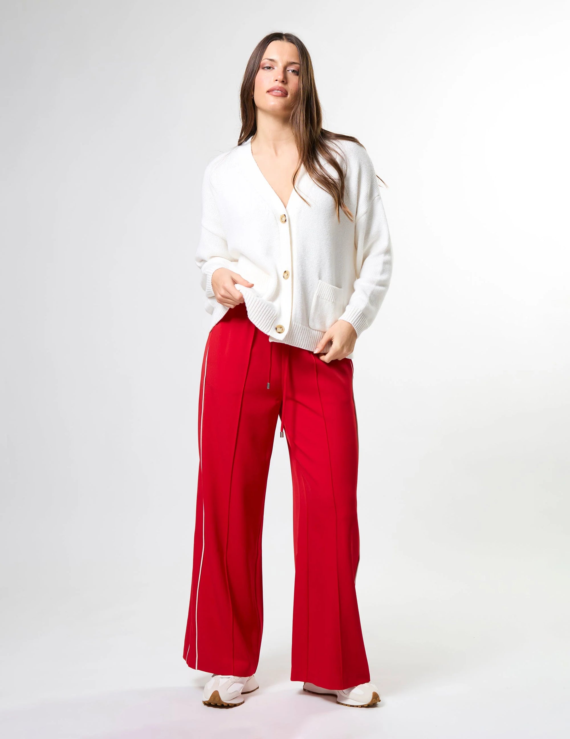 Woman wearing wide leg red pants with drawstrings and white stripes on sides by brand Stella & Gemma on a white background front view 