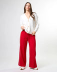 Woman wearing wide leg red pants with drawstrings and white stripes on sides by brand Stella & Gemma on a white background front view 