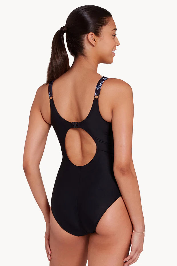 Women in Classique Ankor Clipback one piece swimwear in black with wave patterns by Zoggs with v neck and full coverage and eco sensitive fabric for B-E cup size bust back view